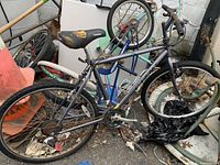 Side view of the Yukon Giant mountain bike leaning against other bikes and objects, showing the frame, seat, and tires.