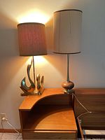 Two lamps on wooden surface against wall, one illuminated