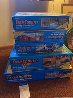 Four stacked ERTL FarmCountry cardboard building sets in original boxes