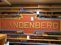 Front view of entire sign mounted on wall with model trains displayed below