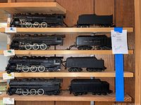 Four locomotive bodies and four tenders on wooden shelving