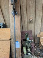 Overall view of plank-mounted bench shear arm and Unimat SL mini lathe components against a wooden wall