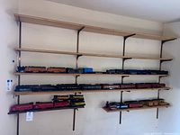 Overview of multiple shelves with assorted train locomotives and cars