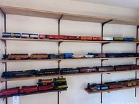 Wide shelf view with multiple train locomotives and cars on four levels