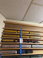 Five yellow passenger cars on top shelf