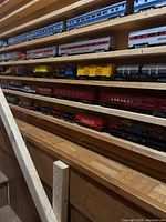 Shelves displaying numerous blue and silver plastic passenger cars and freight cars