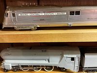 Stainless steel Boston & Maine diesel loco #6000 and unpainted steam boiler/tender on shelf