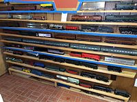 Overview showing three wooden shelves with assorted model trains and cars