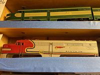 Silver/red Santa Fe diesel locomotive #360 on shelf