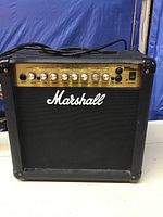 Front view of Marshall MG15DFX amplifier showing control panel, input jack, and power switch with Marshall logo and black speaker grille.