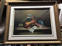 Full view of framed oil painting depicting violin, sheet music, and books.