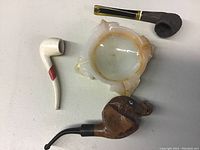 Photo showing the Mexican onyx ashtray and three pipes including the carved elephant head pipe with visible broken tusks.