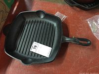 Top view of cast iron grill pan showing grill ridges and handle with hole for hanging.