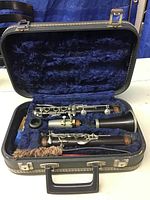 Disassembled clarinet components in original case with cleaning brush
