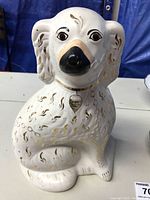 Front view of antique porcelain dog figurine showing facial details and painted texture.