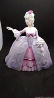 Front view of the Franklin porcelain figurine depicting a woman in a lavender and pink 18th century dress with detailed sleeves and skirt.