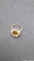 Top angled view of the 10K gold ring with yellow rectangular gemstone on dark background.