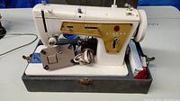 Singer sewing machine model 237 with power cord and foot pedal attached positioned on the hard base inside the case showing detail and condition.