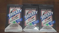 Front view of three unopened 1990-91 Upper Deck NHL Hockey Collector Card Packs, showing details and branding.