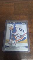 Front of hockey card featuring Connor McDavid in Edmonton Oilers uniform, protected in plastic case.
