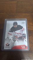 Front image of Mitch Marner rookie card showing player in Team Canada junior uniform skating in game action with the logos and text.