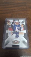 Front of Tom Brady 2010 Donruss Threads football card showing Brady in Patriots uniform and card details.