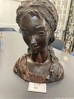 Front view of the bronze lady bust sculpture showing detailed facial features and garment textures.