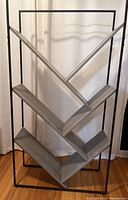 Front view of the metal shelf/bookcase showing the full 5-foot height and V-shaped shelf design.