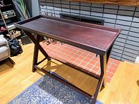 Photo of a new tall wooden side table with tray top, showing its dark wood finish and crossed leg design.