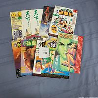Top view of 10 used anime comic books in East Asian language with various anime-style covers.