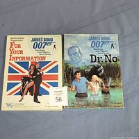 Two James Bond 007 RPG supplements side by side on a surface, 'For Your Information' and 'Dr. No'. Both visibly used with edge wear.