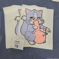 Stack of multiple iron-on heat transfer sheets with cartoon gray cat holding a pink bong illustration.