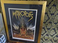 Full frontal view of the framed Metropolis movie poster showing the robot figure and cityscape with title text.