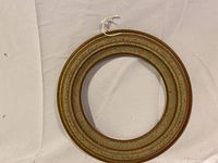 Top view of the round ceramic wall hanging showing concentric rings and speckled glazed texture in earthy tones.