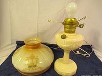 Photo showing converted vintage oil lamp base and separate decorative shade next to it.