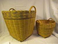 Two wicker baskets side by side on a white cloth backdrop, showing size difference and overall shape.