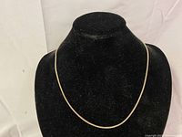 Full view of the sterling silver chain necklace displayed on a black bust stand.