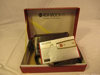 Radio placed inside vintage original RCA Victor red box, with carrying case visible behind radio.