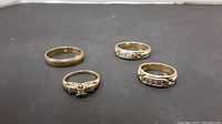 Four rings displayed together on black mat