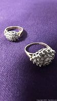 Two 14k gold cluster rings on purple fabric background