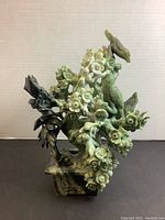 Front view of jade carving showing birds sitting on flowering branches and detailed base.