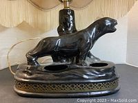 Front angle showing the jaguar figure, circular openings on the base, and part of the lampshade fringe.