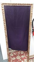 Full view of large rectangular mirror with gold colored composite frame and leaf pattern, measuring 18x50 inches.