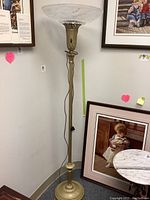 Full view of tall vintage metal floor lamp with large frosted glass shade attached at the top, showing overall structure and height.