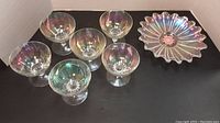 Photo of the 6 vintage opalescent dessert glasses arranged in a semi-circle with the hand-painted glass dish to the side, showing the iridescent glow of the glassware.