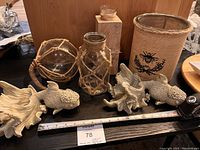 Full set of seaside-themed decorative items arranged on a table including vases, ceramic fish ornaments, and a candle holder; measuring tape present for scale.