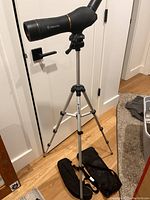 Full view of the Meade telescope mounted on adjustable tripod with carry bag on floor