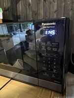 Microwave front showing illuminated digital display with time and power settings