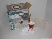 Porcelain Christmas Deer figurine with original box and bubble wrap, showing front view of the deer and box with holiday artwork.