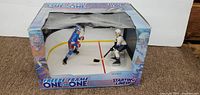Front open box display of two hockey player figures on mini rink
